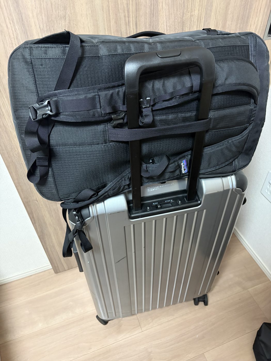 ブラックホール・ミニ・MLC 30Lをスーツケースの伸ばした取手に通して固定した状態